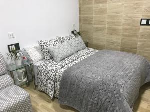 een slaapkamer met een bed en een stoel bij Apartamento Atrapasueños in Cáceres