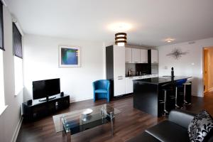 - un salon avec un canapé et une table dans l'établissement The Spires Serviced Apartments Glasgow, à Glasgow