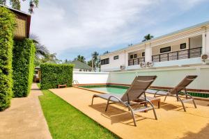 a patio with two chairs and a swimming pool at Blue Wave Samui in Bophut 