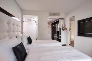 1 Schlafzimmer mit 2 Betten und einem Flachbild-TV in der Unterkunft INNSiDE by Meliá Aachen in Aachen