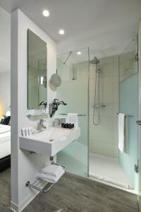 a bathroom with a sink, toilet and shower at INNSiDE by Meliá Aachen in Aachen