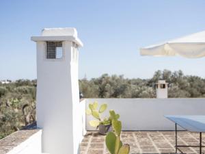 a white lighthouse on a patio with a plant at B&B Medali in Vernole