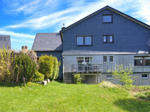 a large house with a blue roof and a yard at Detached house with sauna 50m from ski lifts in Winterberg