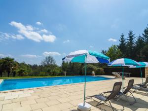 2 sedie e ombrelloni accanto alla piscina di Beautiful holiday home with private pool a Saint-Cernin-de-lʼHerm