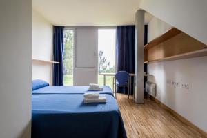 a bedroom with two beds and a large window at Residencia Universitaria O Castro in Vigo