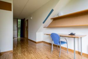 a room with a table and a blue chair at Residencia Universitaria O Castro in Vigo