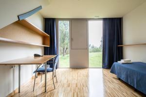 Zimmer mit einem Schreibtisch, einem Bett und einem Fenster in der Unterkunft Residencia Universitaria O Castro in Vigo
