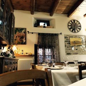 a dining room with tables and a clock on the wall at Albergo del Bramante in Roccaverano