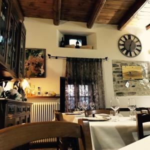 un comedor con mesas y un reloj en la pared en Albergo del Bramante, en Roccaverano