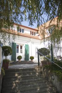 uma casa branca com portas verdes e escadas em Bacchuskeller Eva Lambauer em Gamlitz