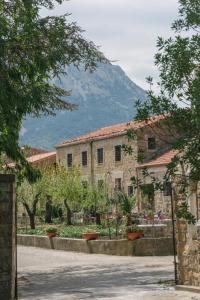 a stone building with a mountain in the background at Feudo Galefona in Gratteri