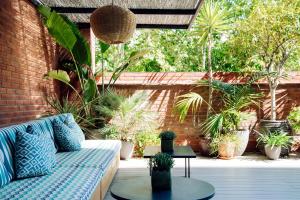 a patio with a couch and a table and plants at Chic & Basic Velvet in Barcelona