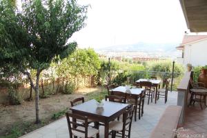 una fila de mesas y sillas en un patio en Torre Ancinale, en Soverato Marina