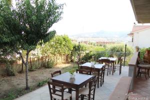 szereg stołów i krzeseł na patio w obiekcie Torre Ancinale w mieście Soverato Marina