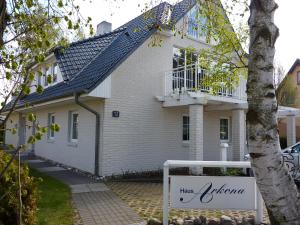 une maison blanche avec un panneau devant elle dans l'établissement Appartement "Ostsee", à Zingst