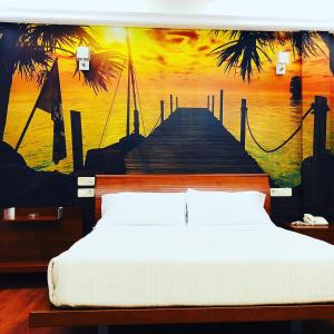 a bedroom with a bed and a painting of a pier at Motel Abalo in Catoira