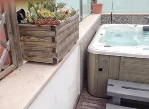 een badkamer met een jacuzzi en een wastafel bij Bilocale Attico Villamarina in Cesenatico