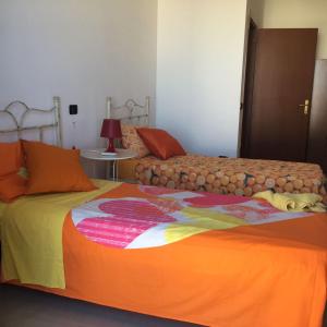 ポルト・チェザーレオにあるCasa Vacanza Porto Cesareoのベッドルーム1室(カラフルな毛布付きのベッド2台付)