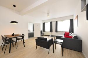 a living room with a couch and a table and chairs at House 22 in Kortrijk