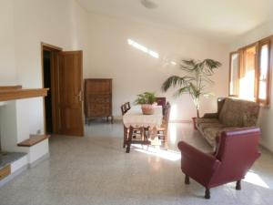 een woonkamer met een bank en een tafel met een plant bij Scalas House in Nurachi