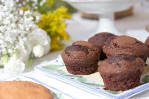 a plate of chocolate muffins on a table with flowers at La Querciolaia B&B in Massa