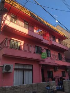 a red building with balconies on the side of it at GreenHotel in Tokyo