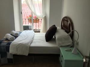 a bedroom with a bed with pillows and a window at San José Guest House in Granada