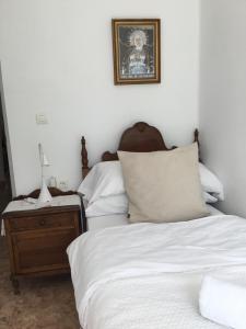 a bedroom with a bed and a nightstand next to a bed at San José Guest House in Granada