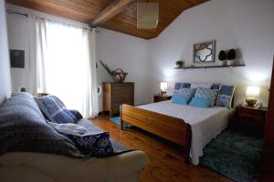 sypialnia z łóżkiem i kanapą w obiekcie Casa da Roseira w mieście Nordeste