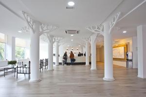 una habitación con columnas blancas y gente caminando en ella en HYB Eurocalas, en Calas de Mallorca 63 fotos más