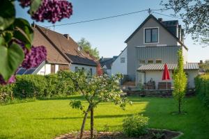 a house with a green yard with a small tree at Feriendomizil "Alte Post" I in Pronsfeld