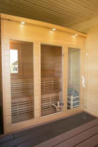 una sauna con puertas de cristal en una pared de madera en Maushaus, en Véménd