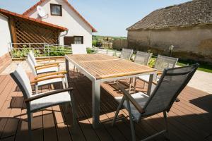 una mesa de madera y sillas en una terraza en Maushaus en Véménd