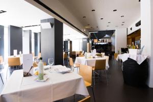 un restaurante con mesas y sillas con manteles blancos en Hotel Blu Puerta de Almansa, en Almansa