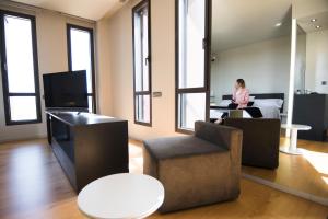 una habitación con una mujer sentada en un escritorio en una habitación en Blu Hotel Almansa en Almansa