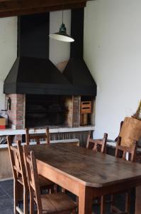 uma sala de jantar com uma mesa de madeira e uma lareira em Hospedaje 371 em Salta