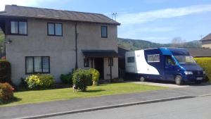 un camion bianco e blu parcheggiato di fronte a una casa. di Eagles View a Llanrwst