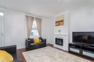a living room with a television and a fireplace at Alabama Place in Plumstead