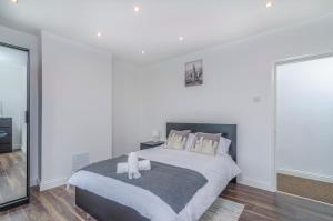 a bedroom with a large bed with white walls at Alabama Place in Plumstead