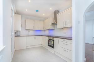 a kitchen with white cabinets and a sink at Alabama Place in Plumstead