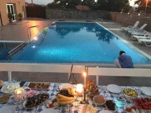 una mesa con comida junto a la piscina en Byala Residence Apartments, en Byala