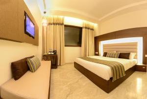 Habitación de hotel con cama y TV en Hotel Alleviate en Agra