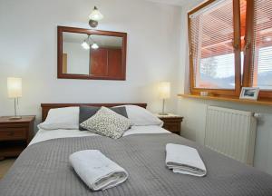 sypialnia z dużym łóżkiem i dwoma ręcznikami na nim w obiekcie Apartament BazaTatry Giewont View w Zakopanem