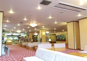 eine Bibliothek mit Stühlen und Tischen in einem Gebäude in der Unterkunft Higashiyama Park Hotel Shinfugetsu in Aizu-Wakamatsu