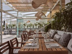 a restaurant with a long wooden table and chairs at Hotel St.John Suites Adults Only in Tsilivi