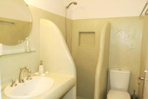 bagno con lavandino, servizi igienici e specchio di Villa Viglakia a Naoussa