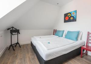 a bedroom with a bed with a painting on the wall at Vakantiehuis Stadszicht in Ootmarsum