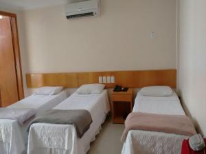 科拉蒂納是的住宿－Hotel Sao Miguel，客房设有三张床和一张书桌