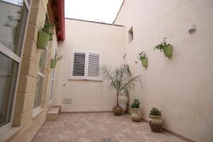 a courtyard with potted plants on the side of a building at Corte Manzoni in Melendugno