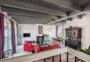 a living room with red chairs and a table at Vakantiehuis Stadszicht in Ootmarsum